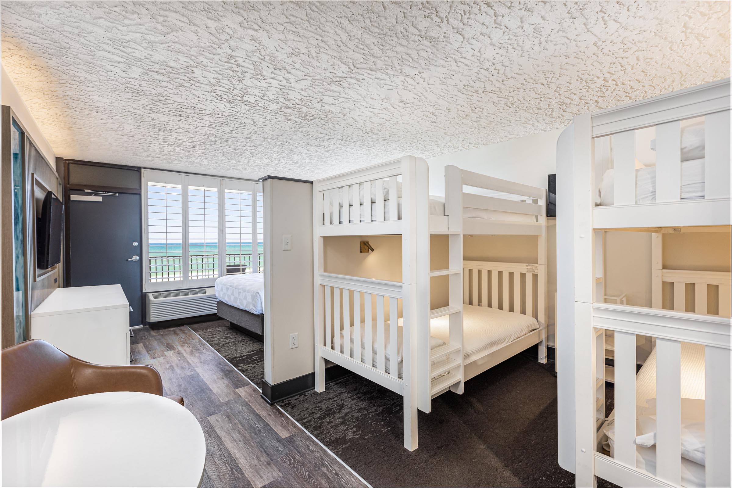 Two white twin bunk beds beside table