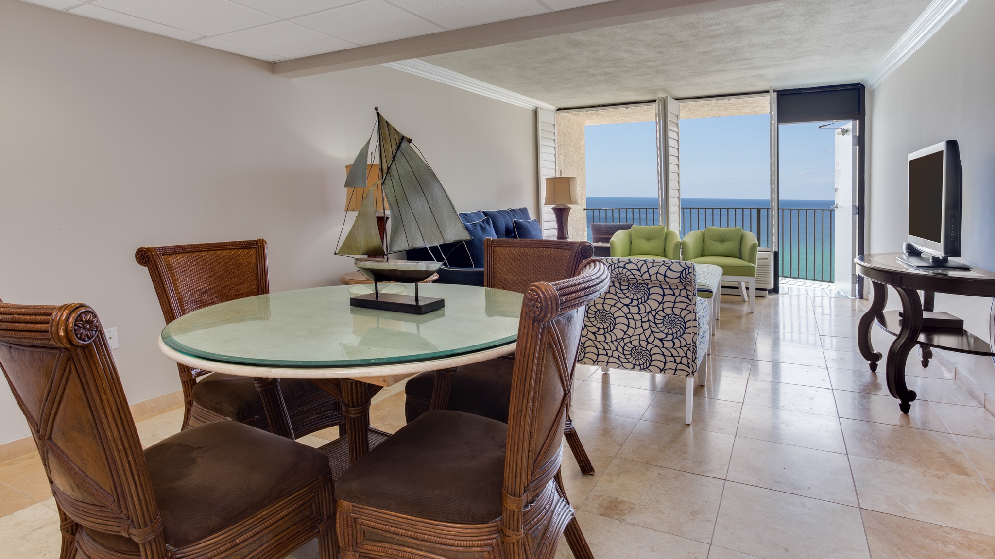 Kitchen table and chairs beside living space and gulf views from floor-to-ceiling windows